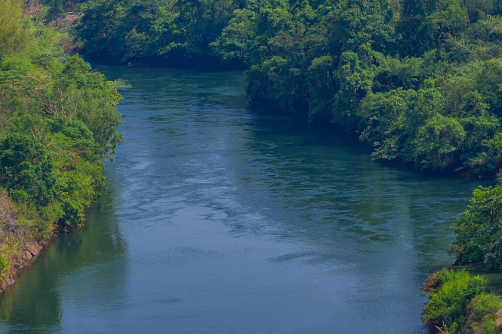 An aerial view of the dam-caused canal in Thailand’s national park, with a mountain the background. Bird eye view. Stock Free