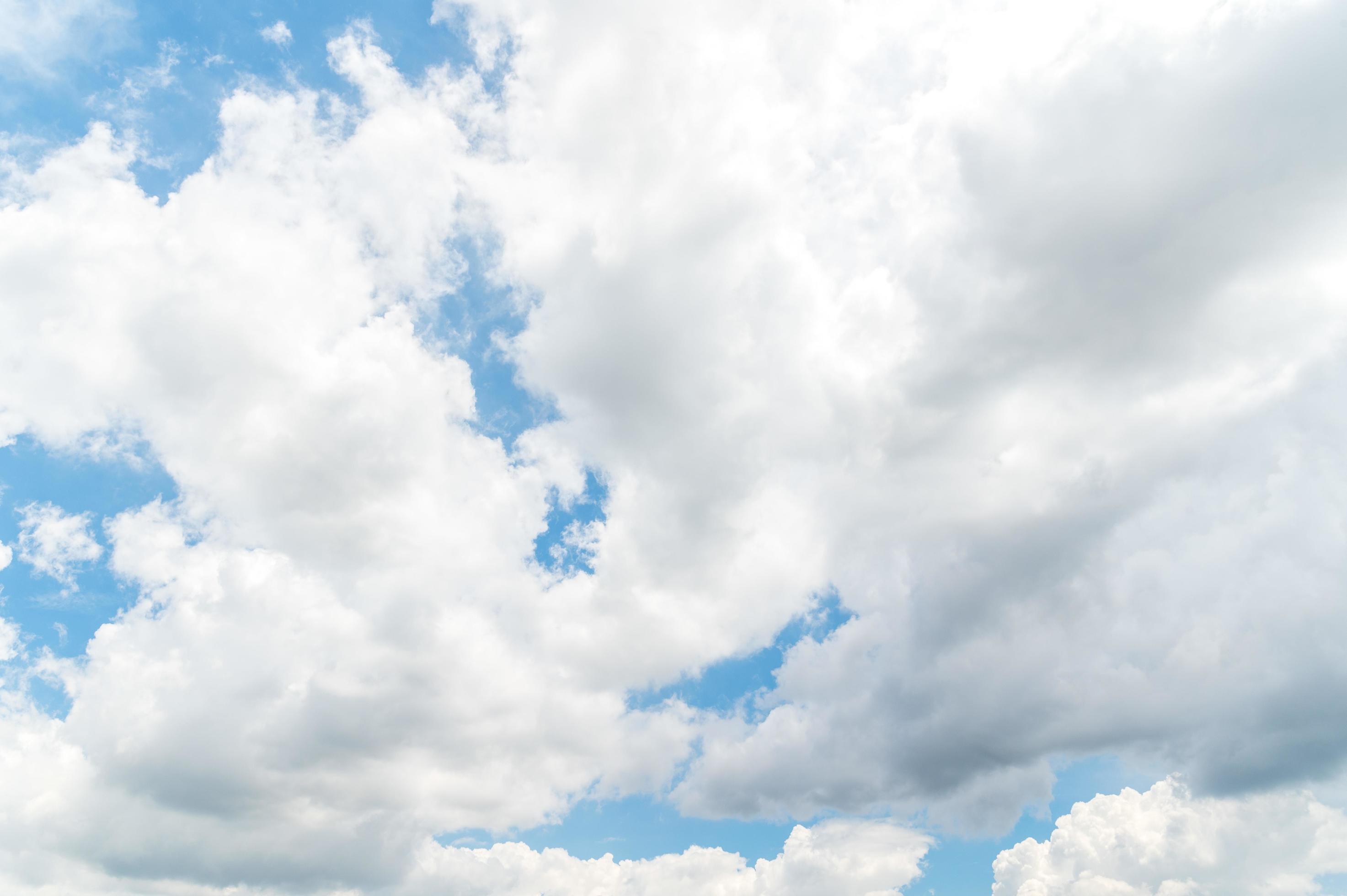 Nature background from white clouds in sunny day. Beautiful white fluffy clouds in blue sky. Stock Free