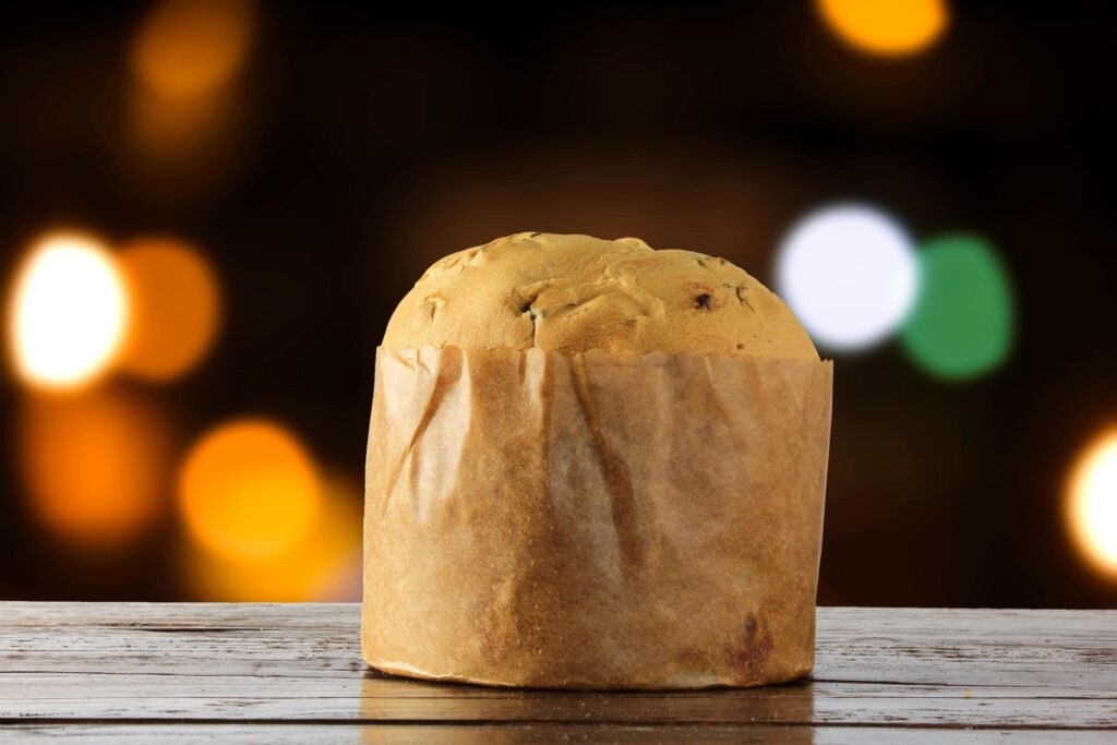 panettone, decorative food, on wooden table, blurred lights in the background Stock Free