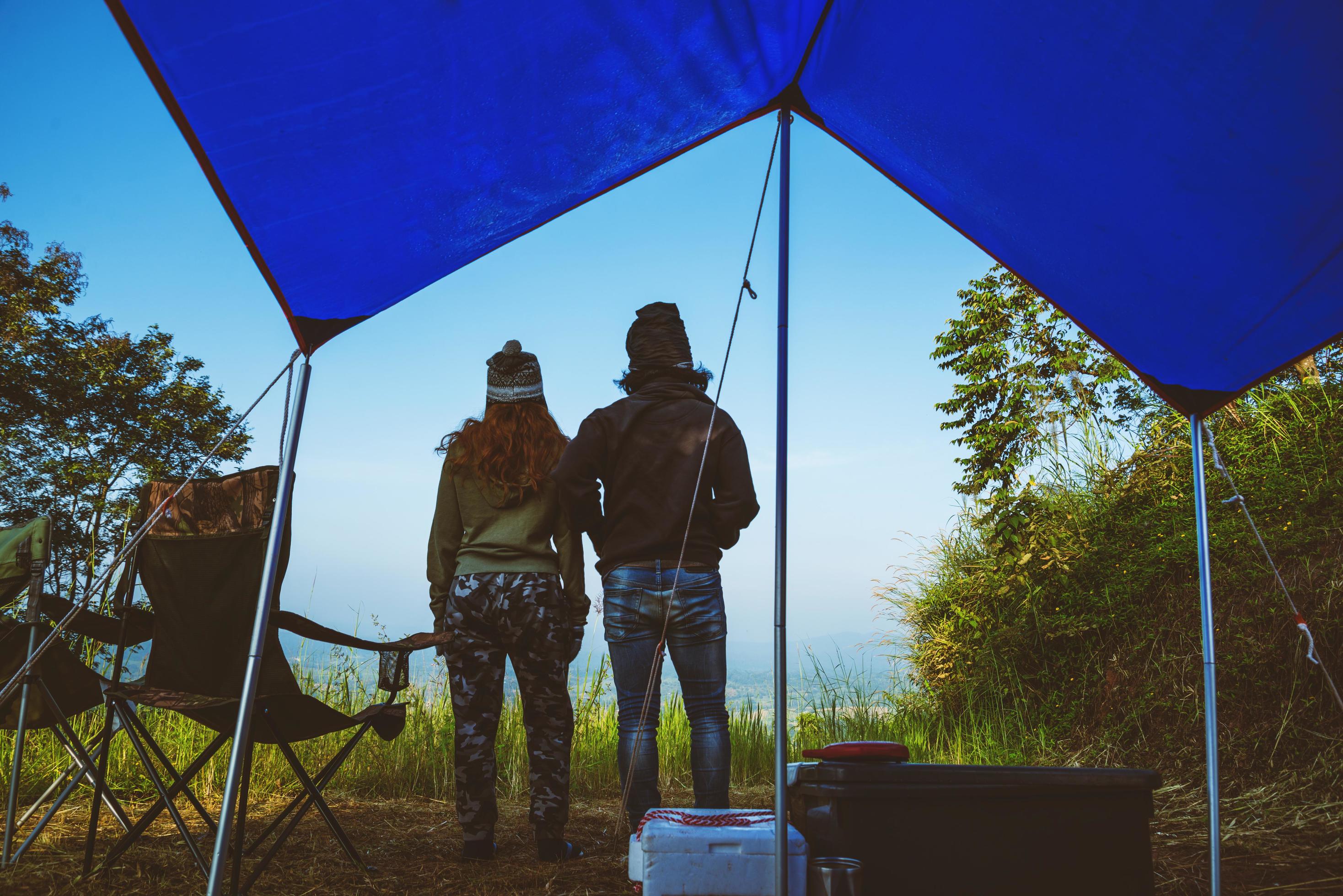 Couples travel camping tent in the holiday. Travel honeymoon couple happy and enjoying a beautiful nature on peak of foggy mountain. Stock Free