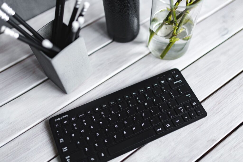 Black keyboard with pencils on a white table Stock Free