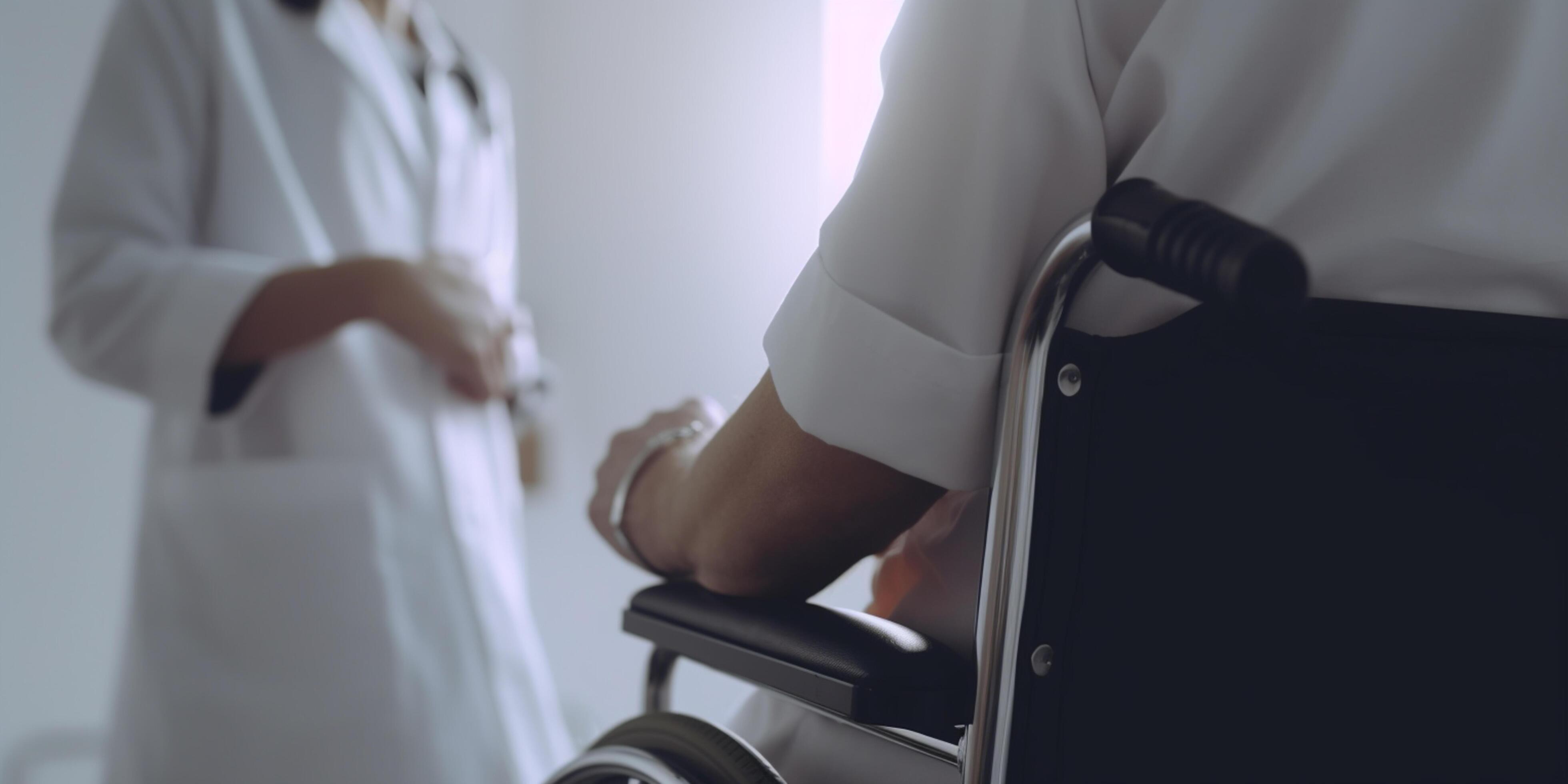 Doctor and patient in wheelchair discussing medical treatment Stock Free