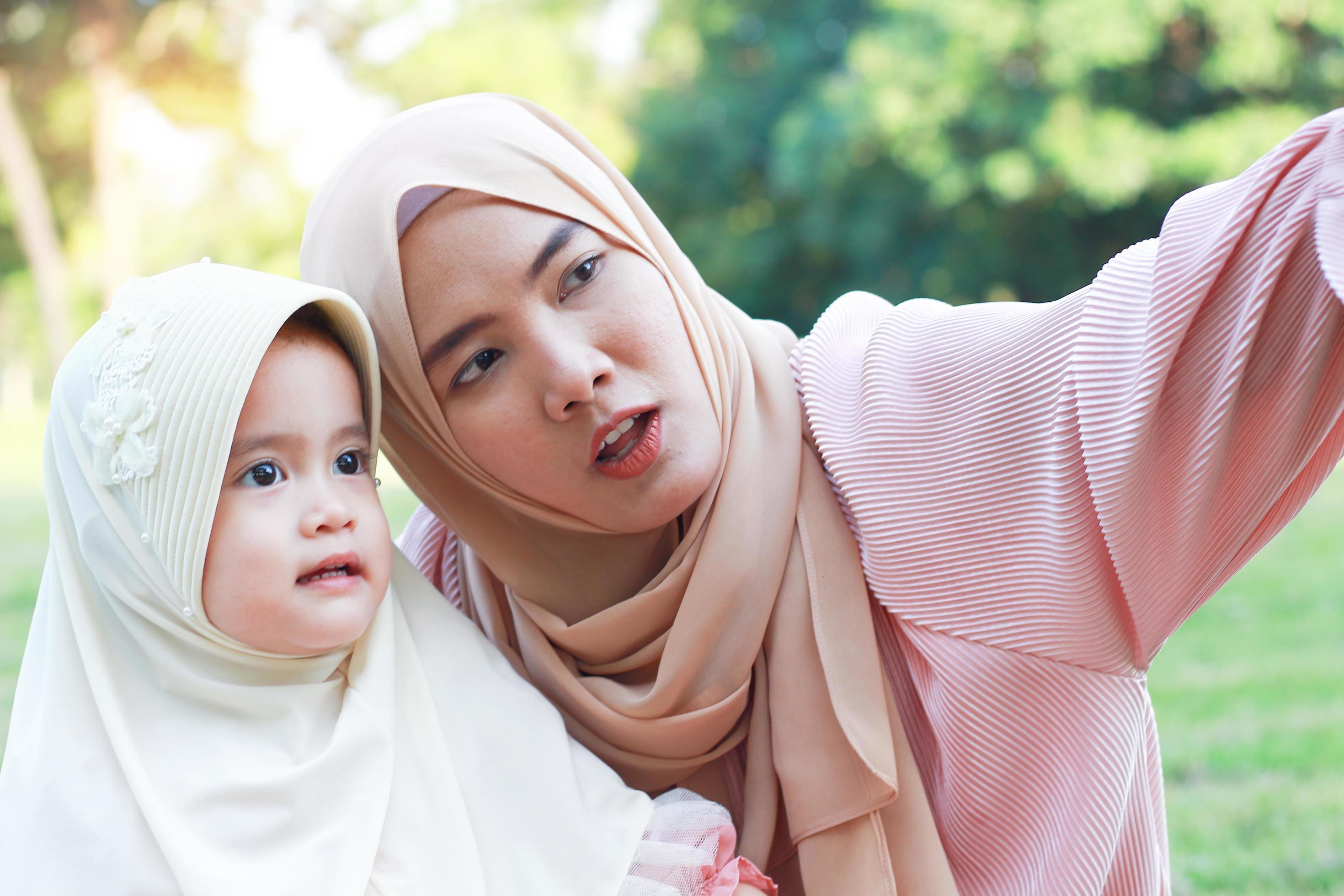 Muslim mother and daughter take a happy selfie in the park Stock Free