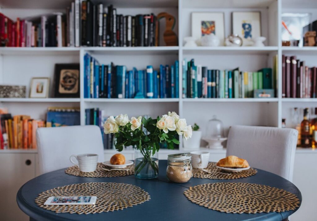 Round breakfast table with white flowers and golden coffee mats Stock Free