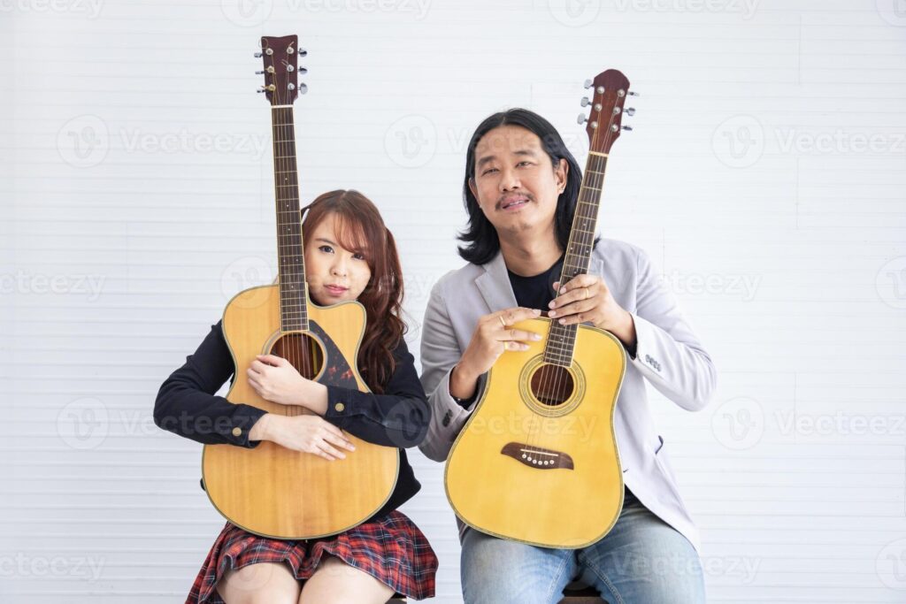 Portrait of Asian family duo band with two guitarist of father and daughter on white background for music, artist, musician style concept Pro Photo