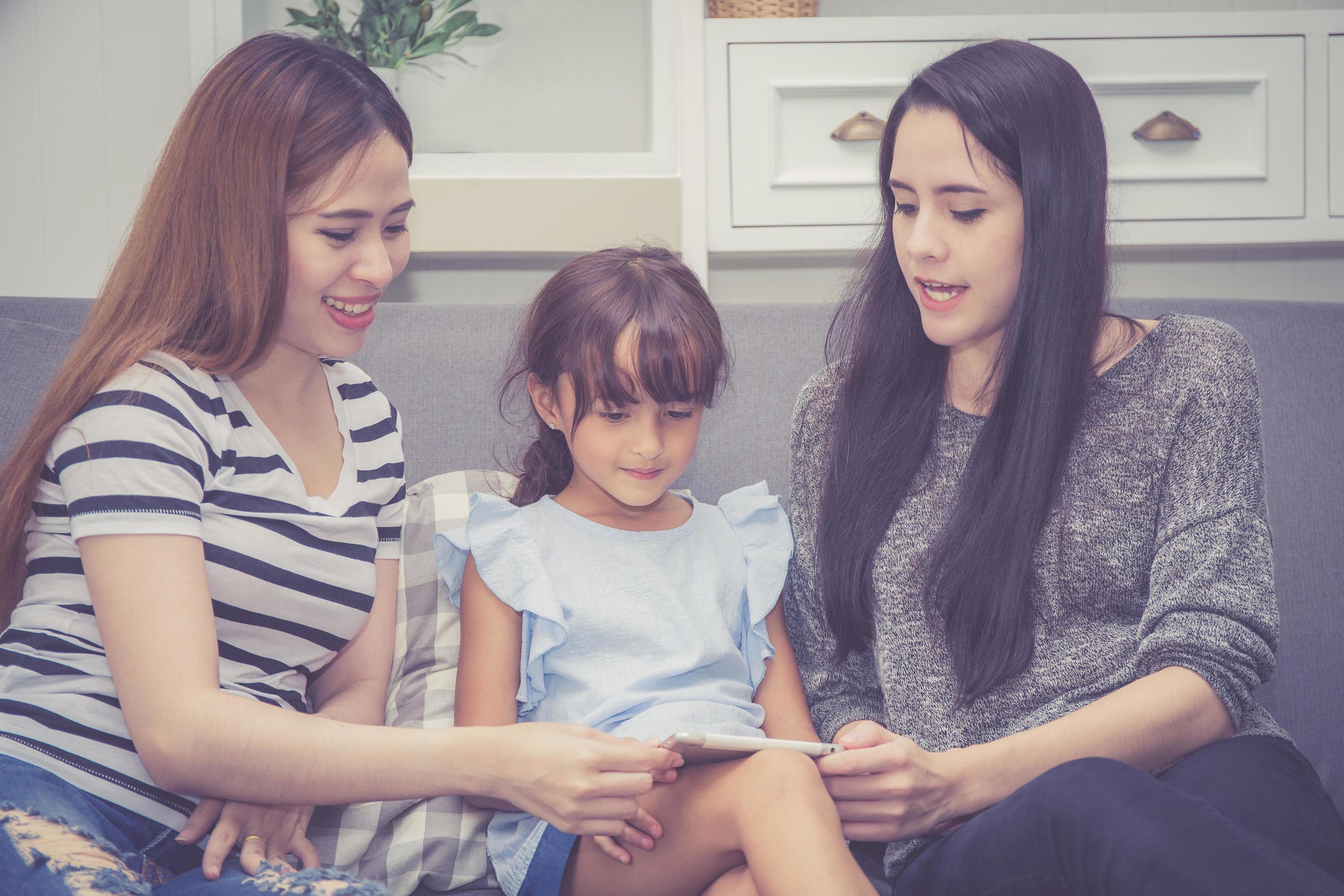 Mother, Aunt and kid having time together lerning with using tablet Stock Free