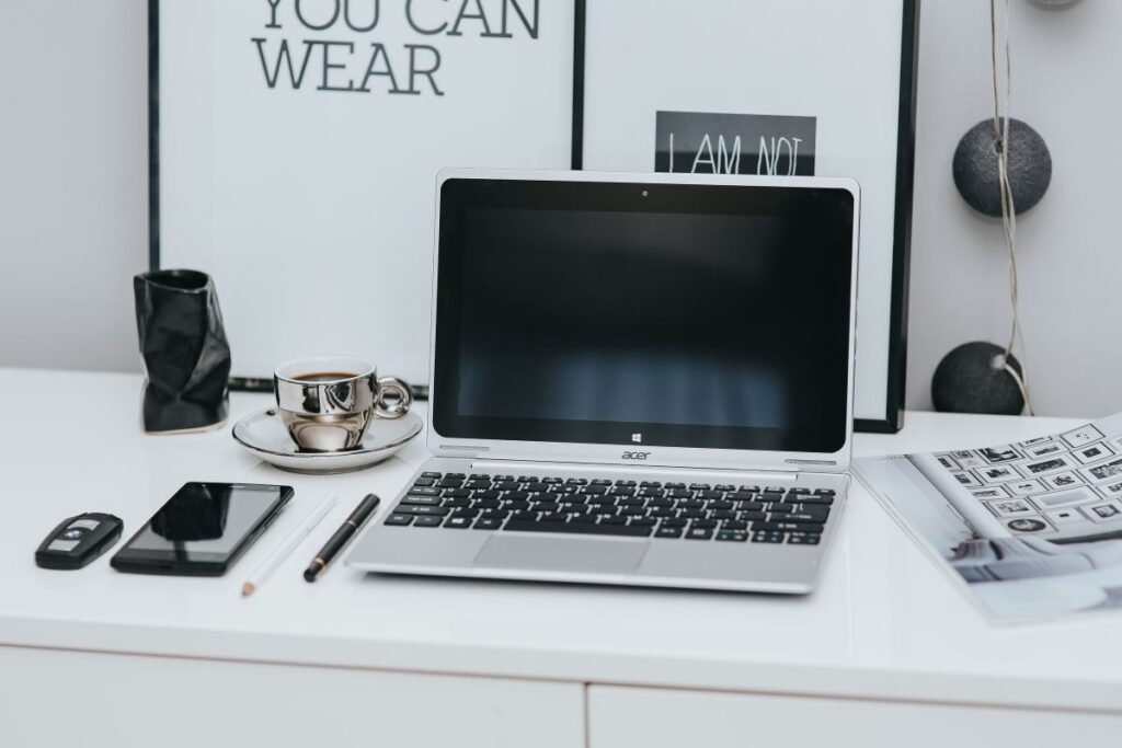 Laptop computer on white desk Stock Free