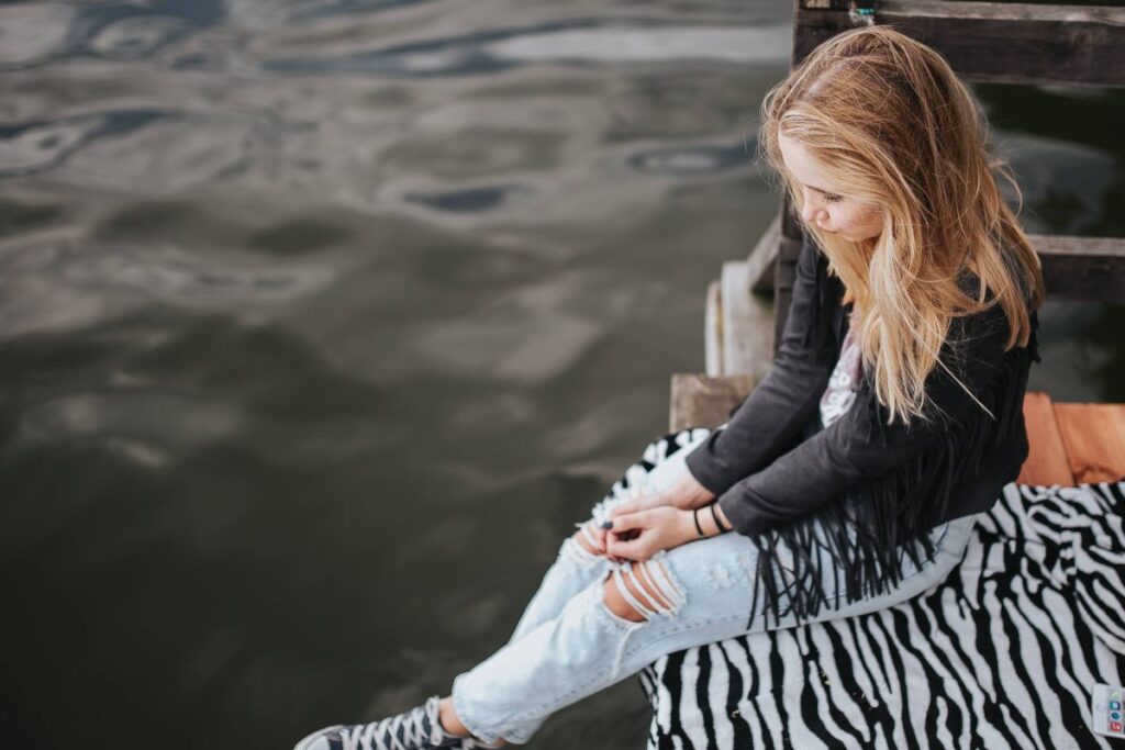 Blonde woman having a healthy snack at the wooden pier Stock Free