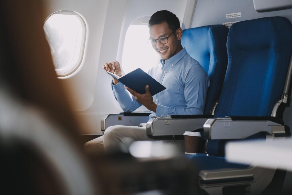 Airplane, travel and portrait of businessman working on laptop computer and smartphone while sitting in airplane. Stock Free