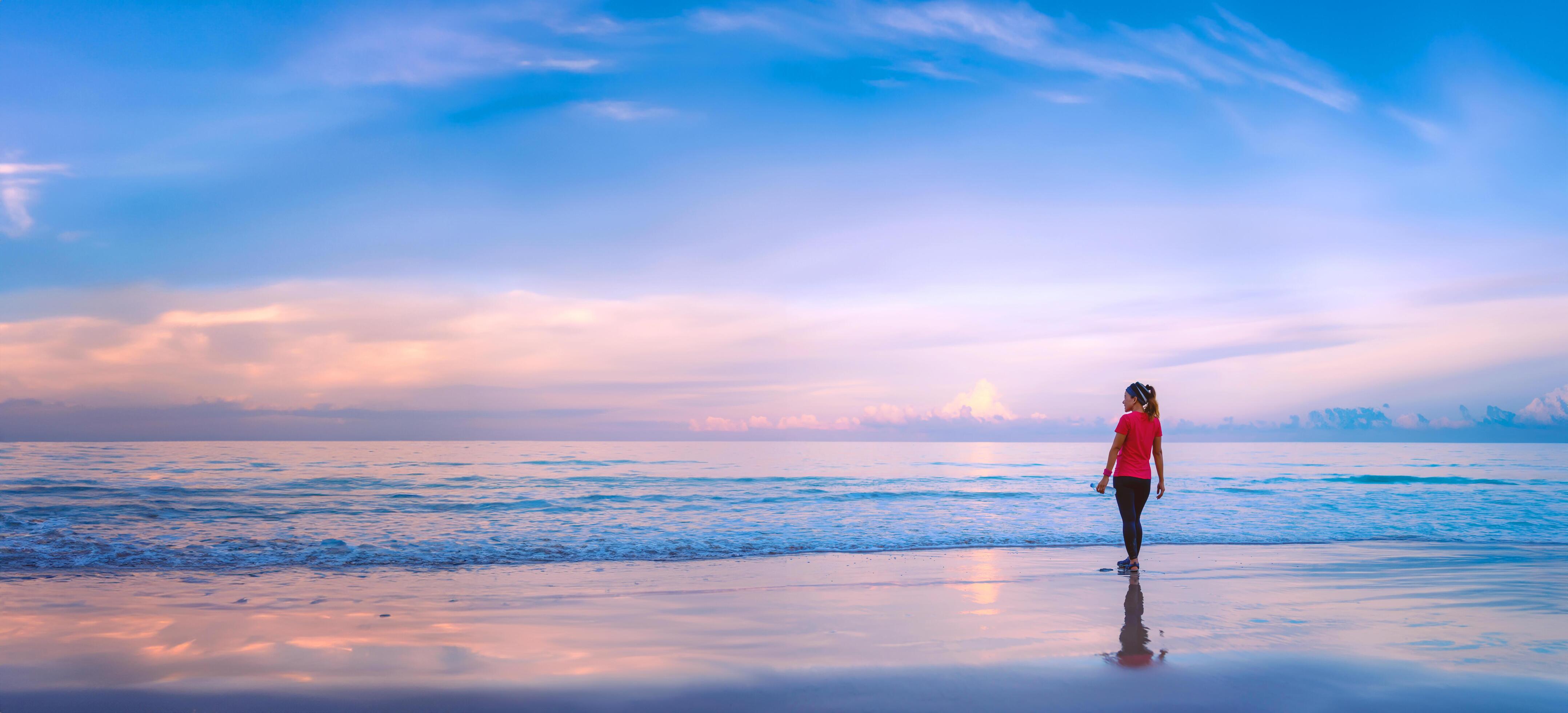 Girl running workout jogging on the beach in the morning. relax and happy with running on the sea. in summer Stock Free