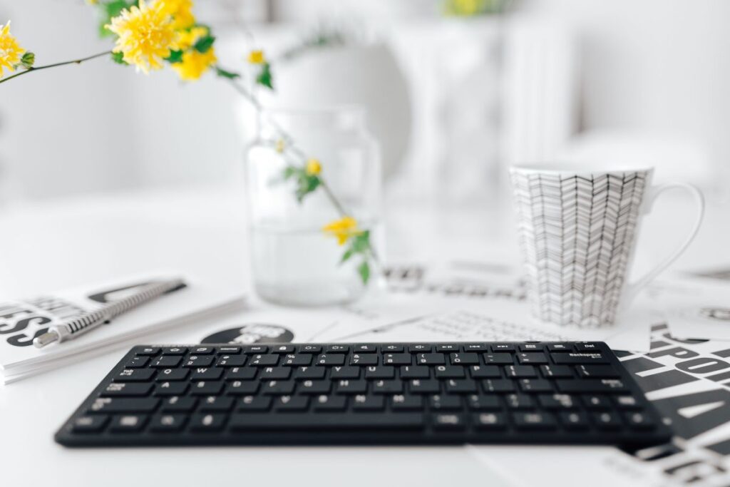 Female hands typing on the remote wireless computer keyboard Stock Free