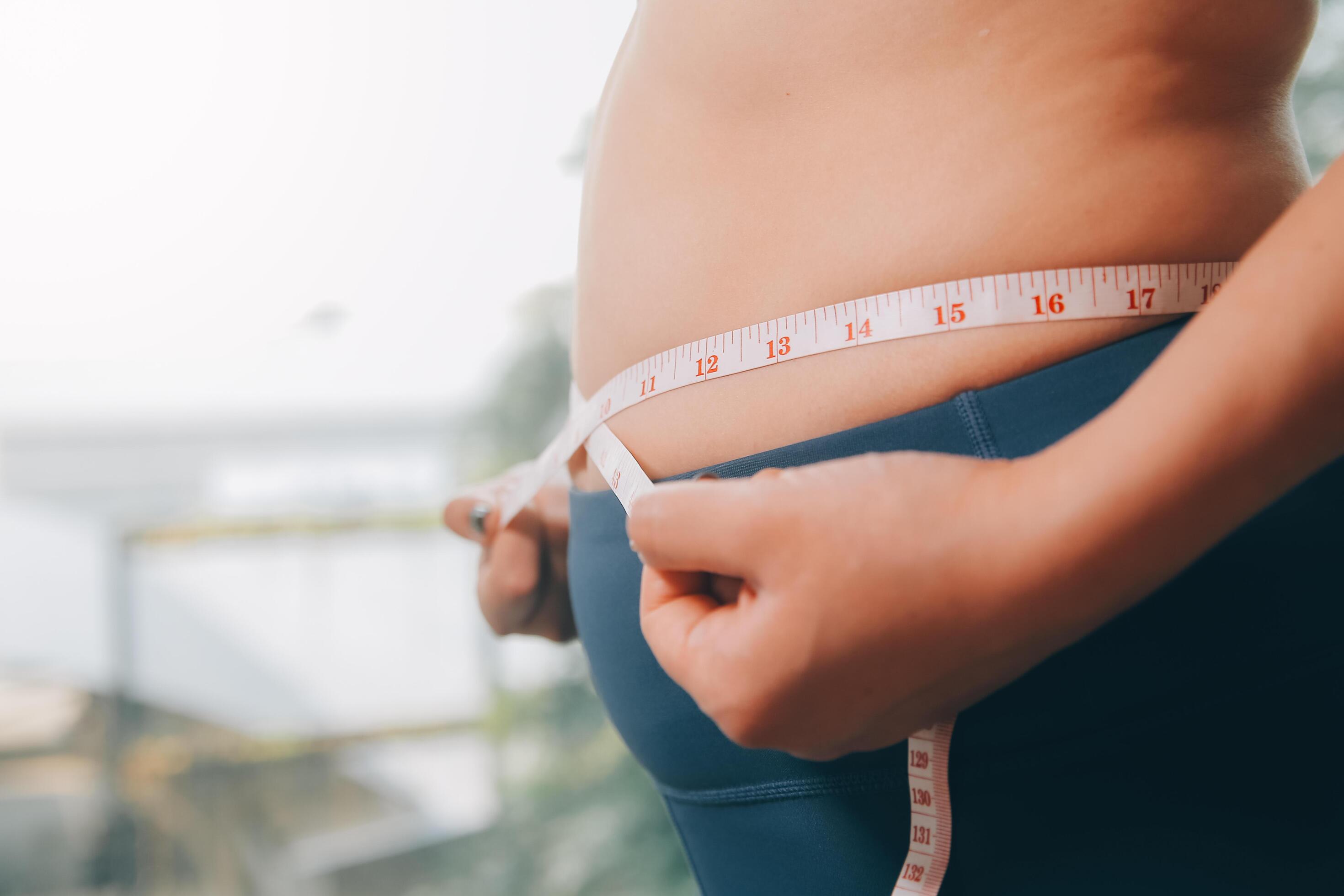 fat woman, fat belly, chubby, obese woman hand holding excessive belly fat with measure tape, woman diet lifestyle concept Stock Free