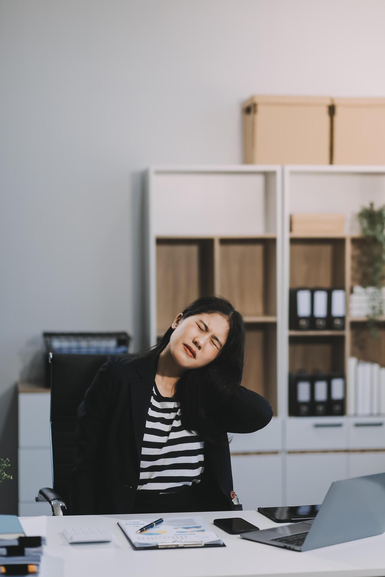 Office asian business woman stretching body for relaxing while working with laptop computer at her desk, office lifestyle, business situation Stock Free