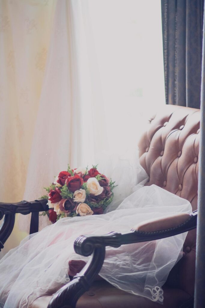 Beautiful rose Flowers bouquet on white vail of bride on vintage chair in wedding ceremony. Valentine day Stock Free