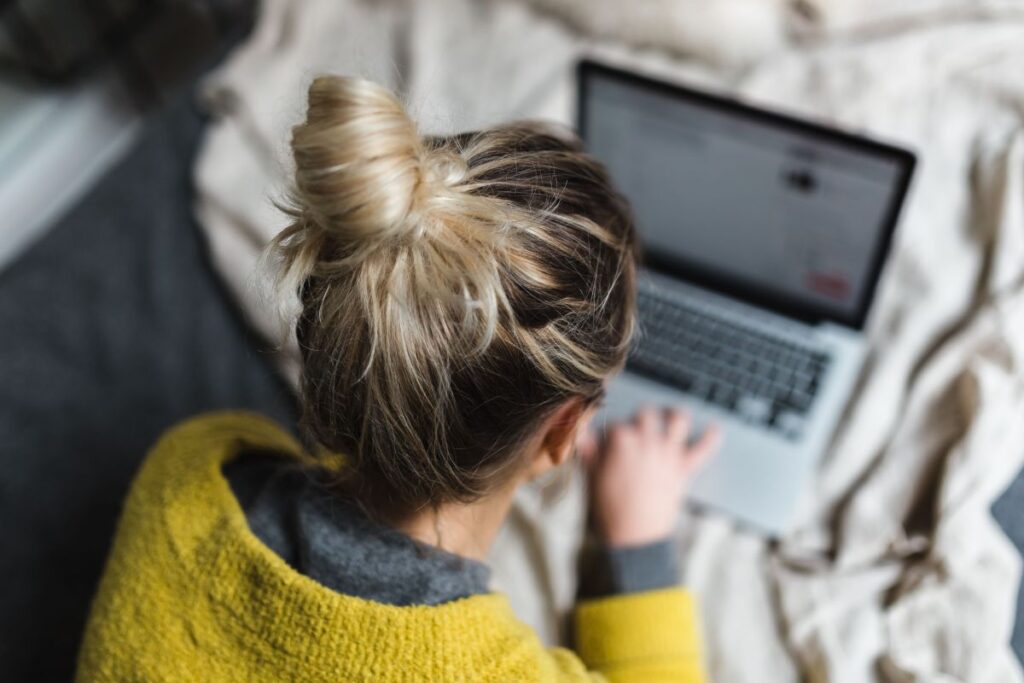 Blond using her laptop at her bedroom Stock Free