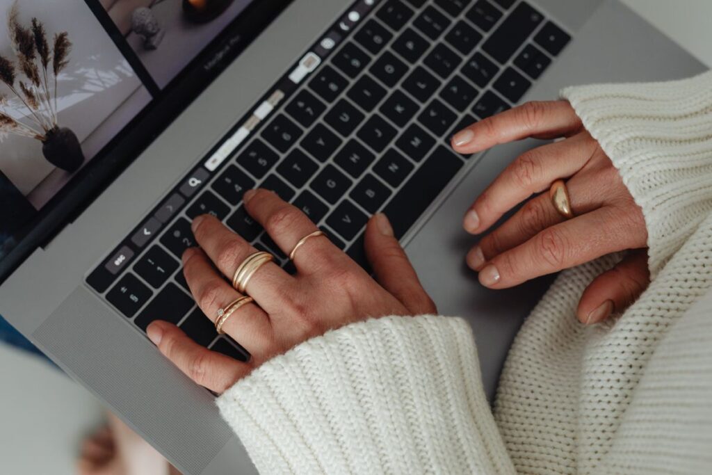 Woman in a white sweater – jewelry – laptop work – fashion Stock Free