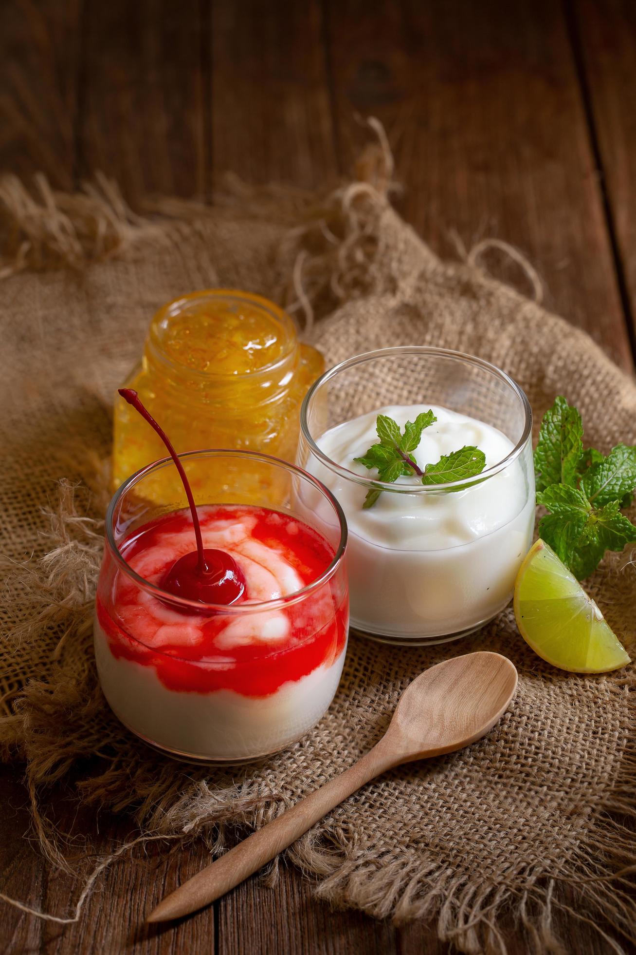 Glass cups of yogurt and fruit on textured cloth Stock Free