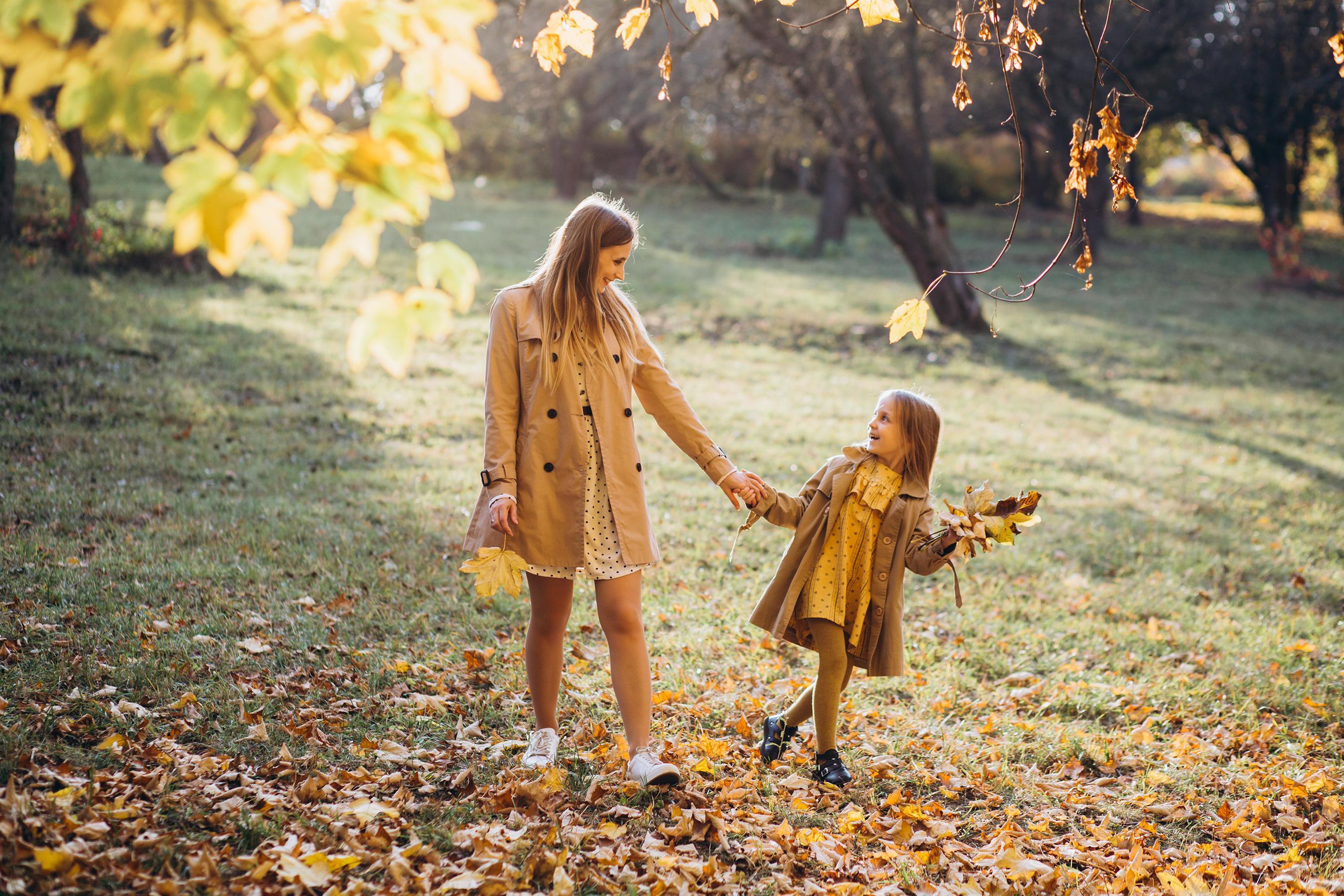 Mother and her daughter have fun and walk in the autumn park. Stock Free