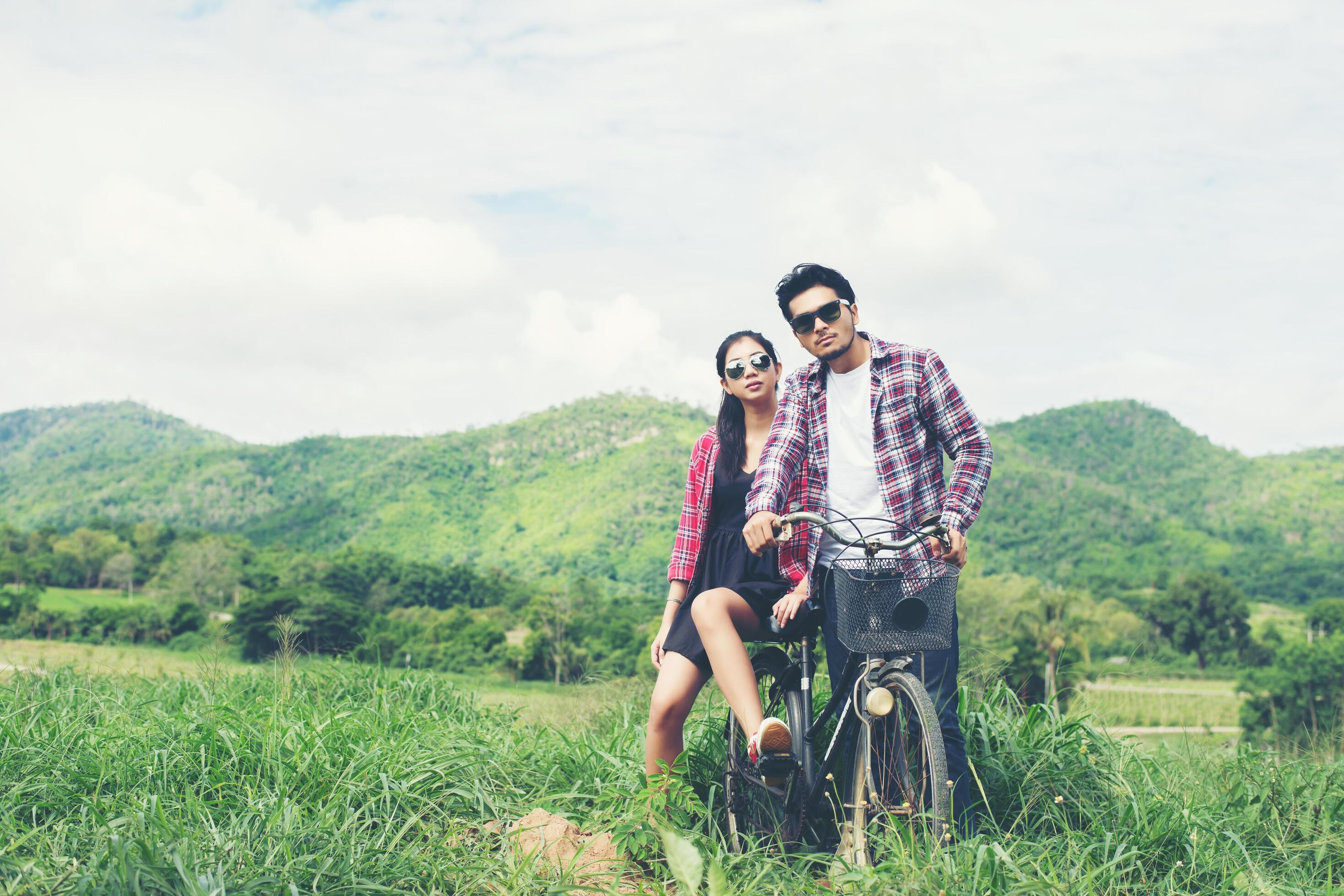 Young hipster couple holding hands walking on the meadow relaxing and natural atmosphere is very natural. Stock Free