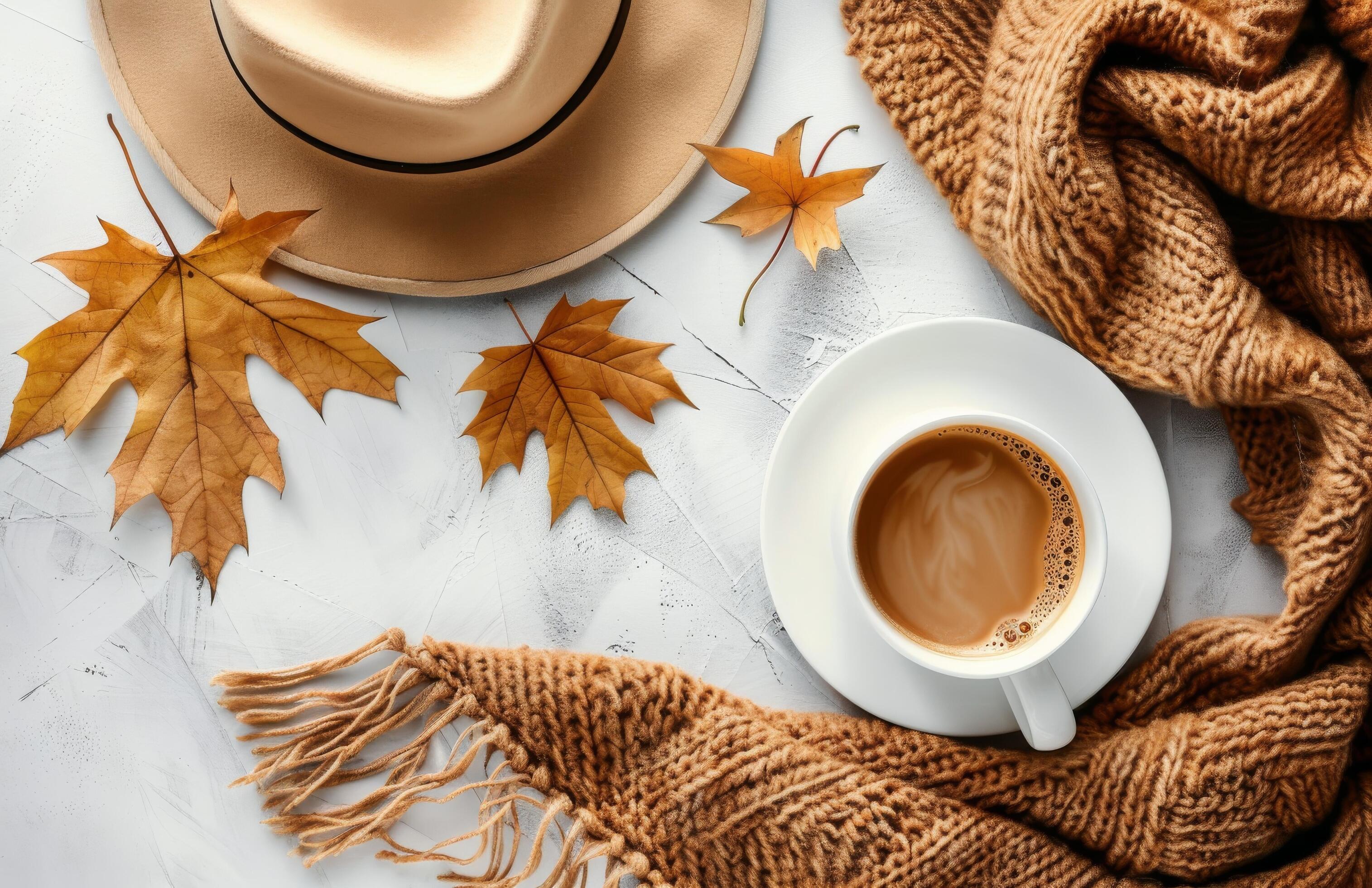 Autumnal Coffee Cup on White Table With Brown Scarf and Fall Leaves Stock Free