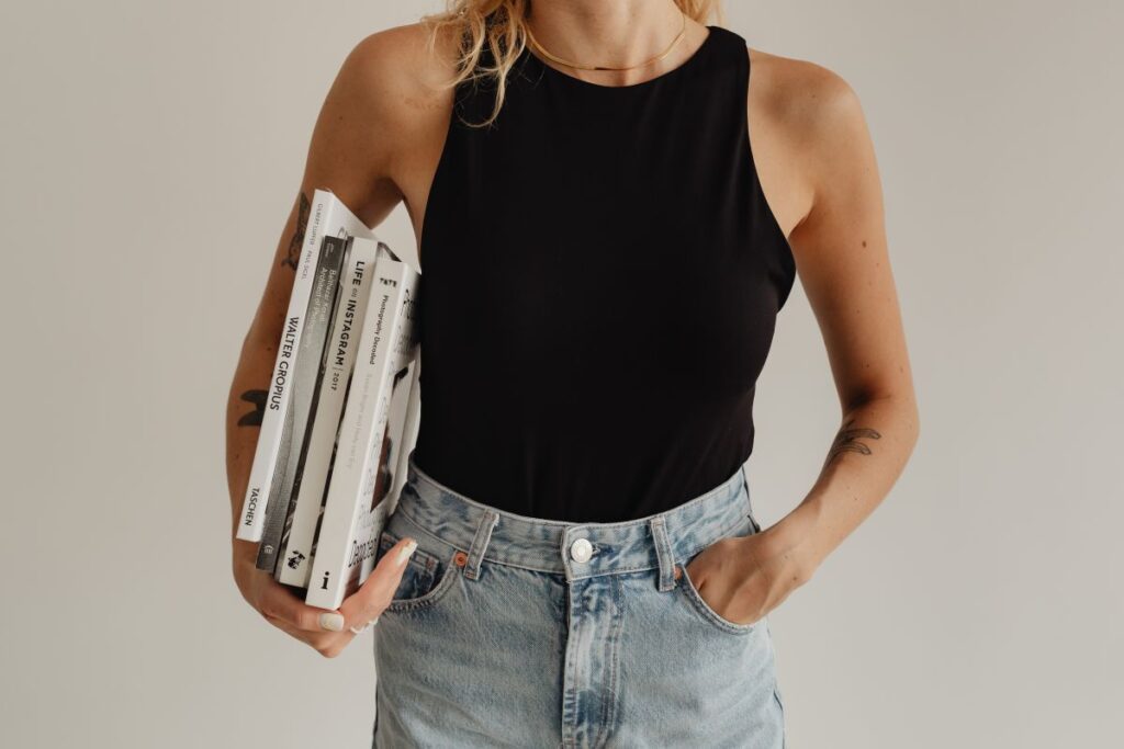 Woman in light-colored jeans with books Stock Free