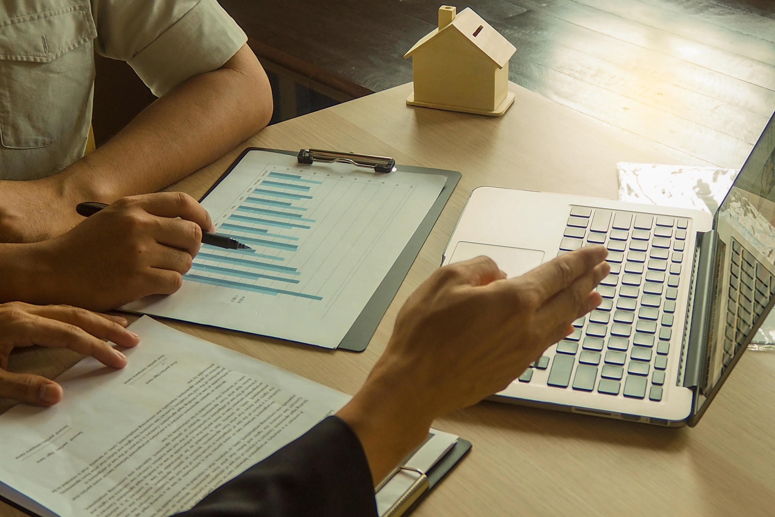 Businessmen are describing investment plans to investors through graph papers and computers Stock Free