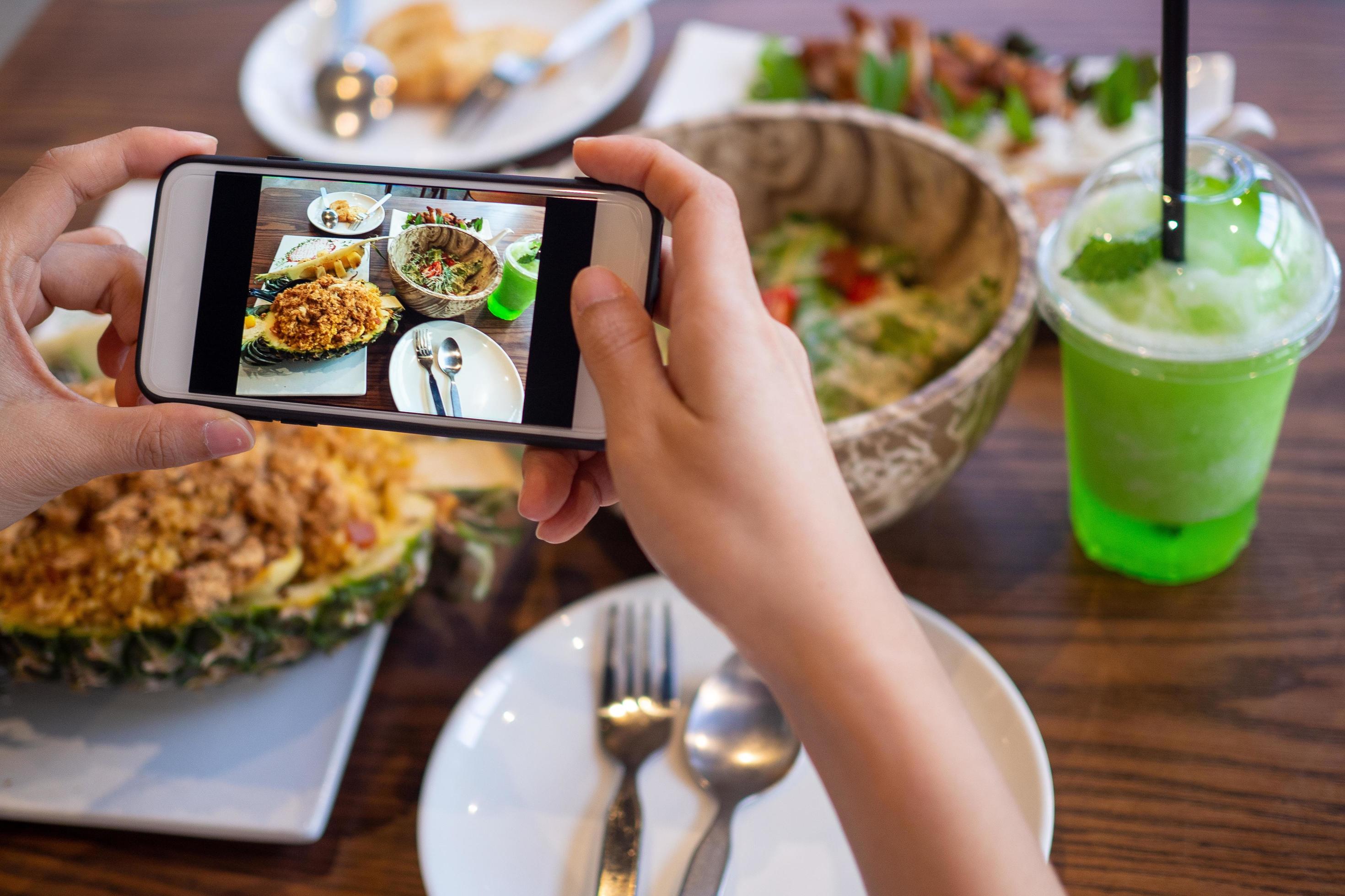 The hand of a woman take pictures of food made by herself. Food sellers take photo with a smartphone to post on the online food ordering website. Stock Free