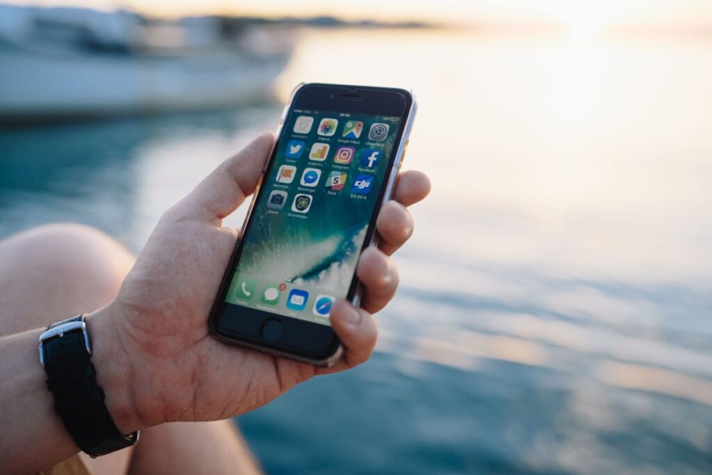 Mobile phone in man’s hands near the sea Stock Free