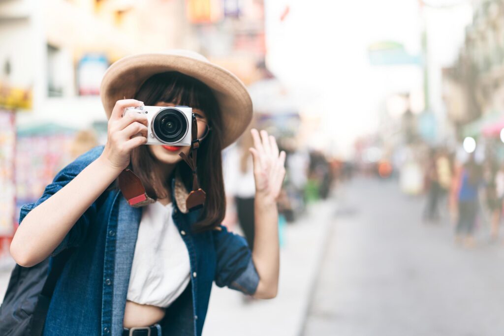 Young asian woman traveller take a photo by camera at khaosan street road. Stock Free