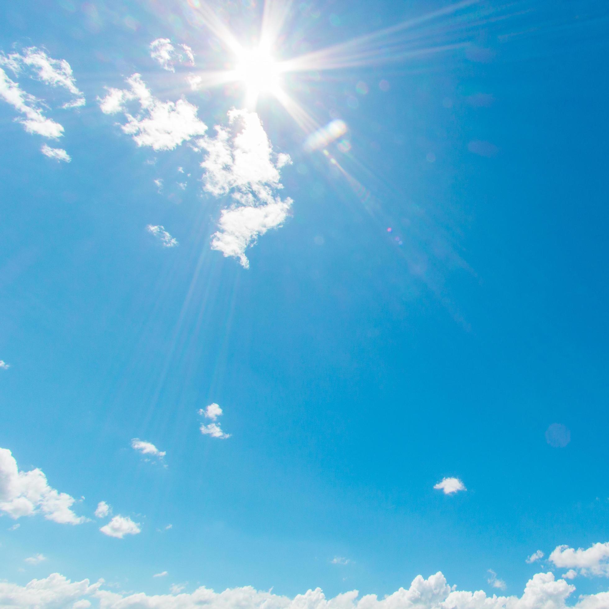 Natural abstract background of bright blue sky and fluffy white clouds on a sunny, light a flare and sun. Stock Free