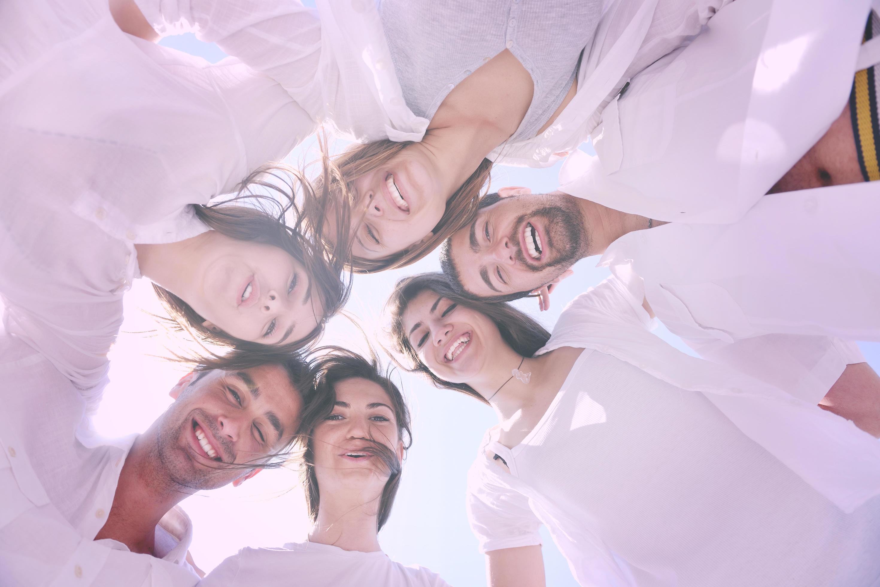 Group of happy young people in circle at beach Stock Free