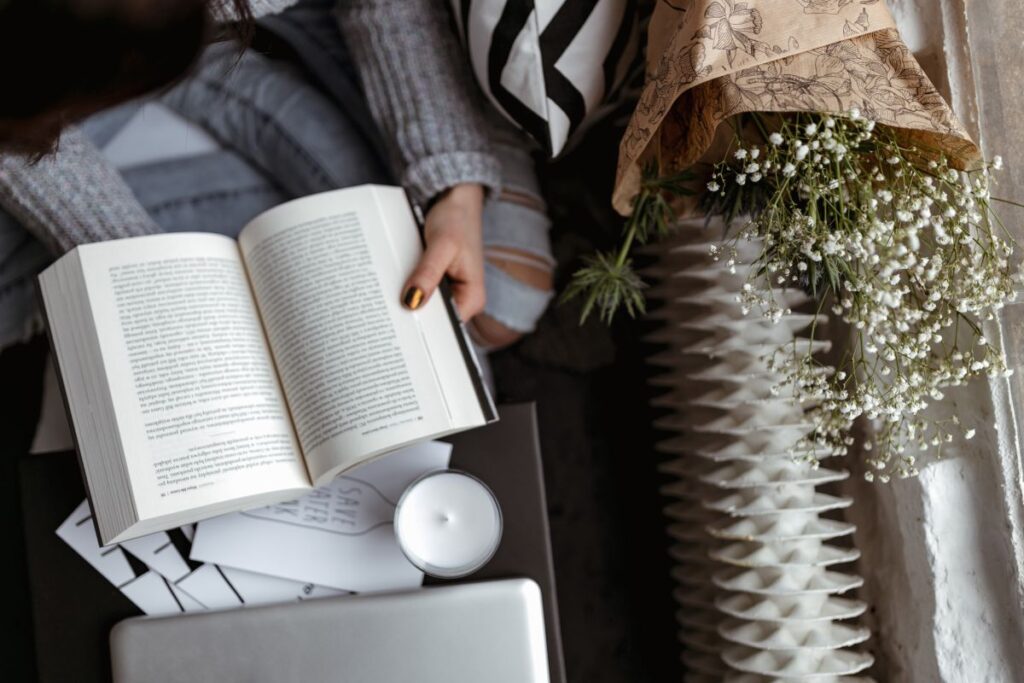 A woman in a sweater reads a book Stock Free