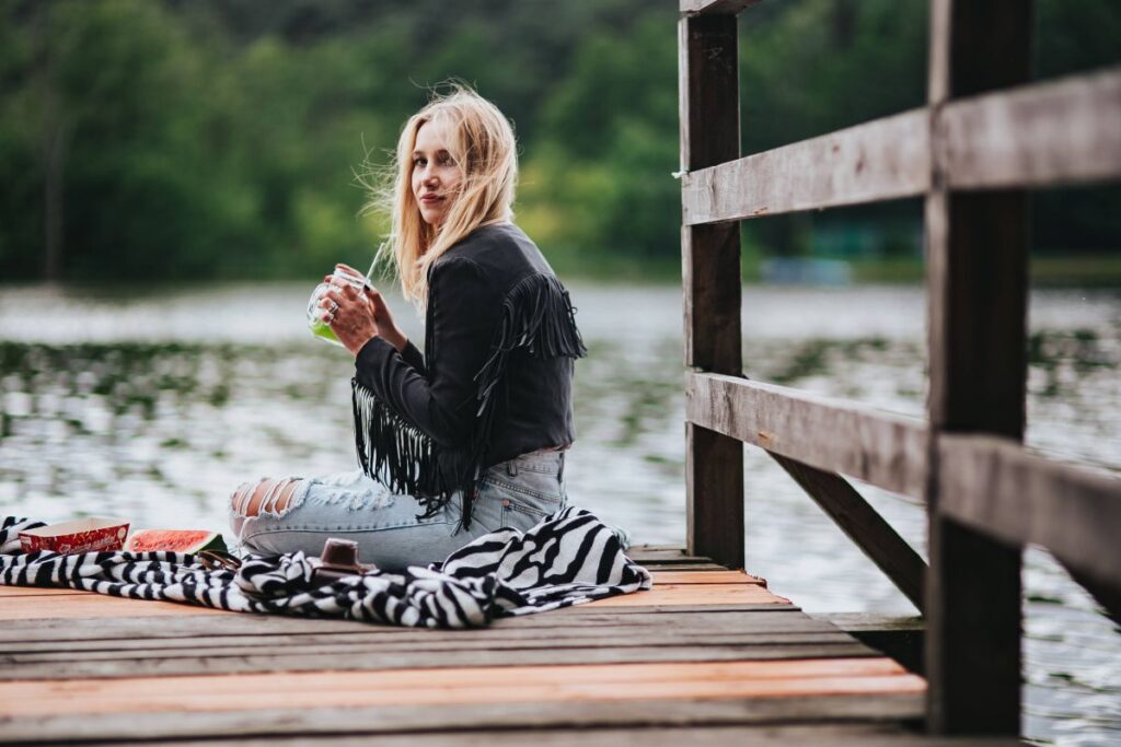 Blonde woman having a healthy snack at the wooden pier Stock Free