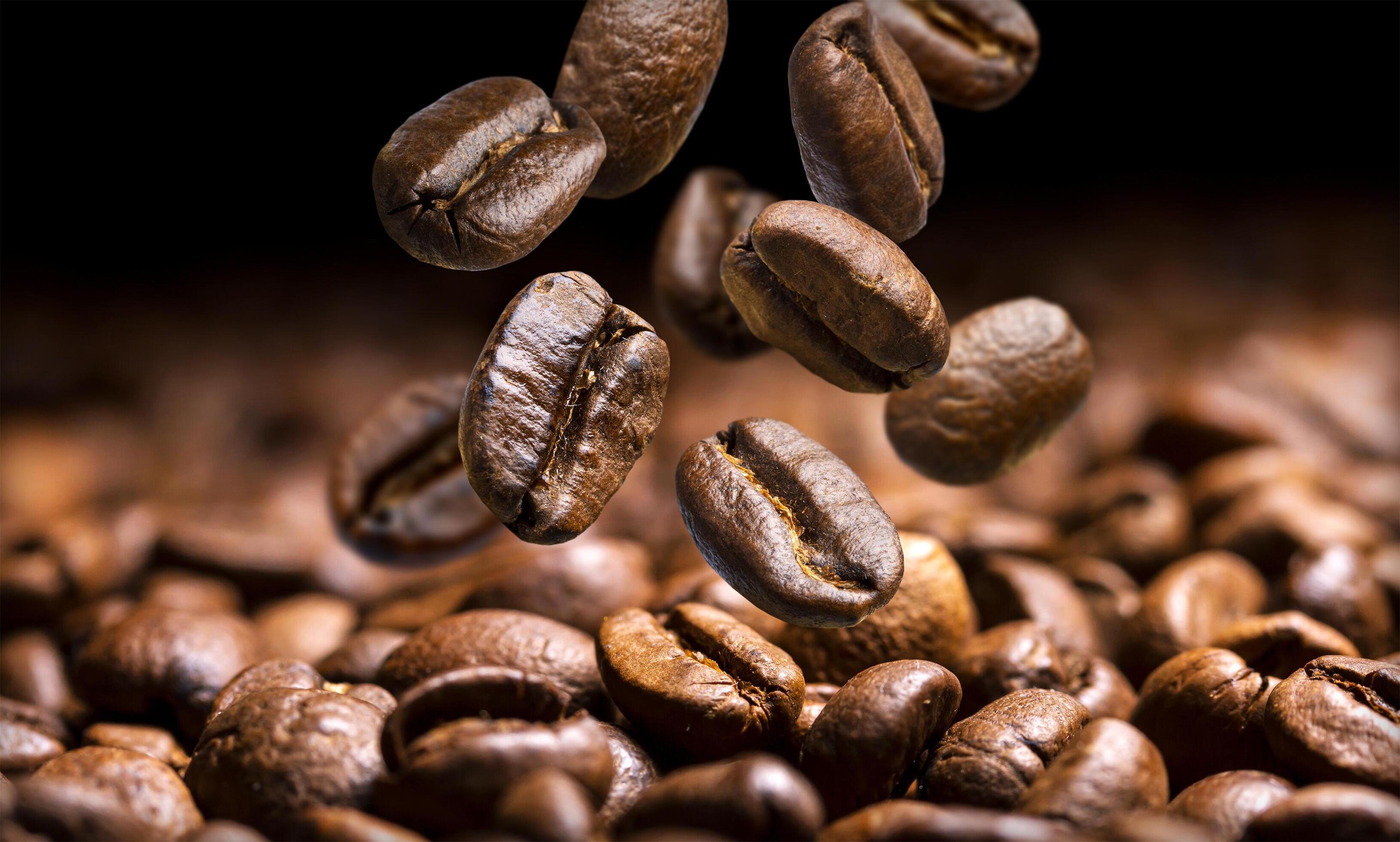 Falling coffee beans close-up, flying coffee beans over dark background Stock Free