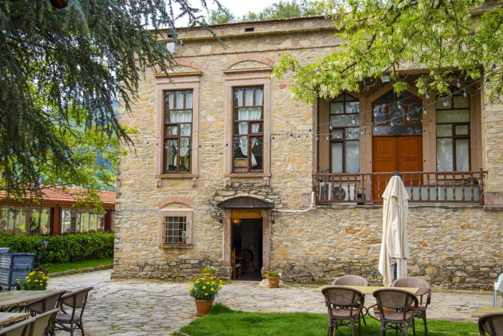 An old stone building next to the cafe tables. Stock Free