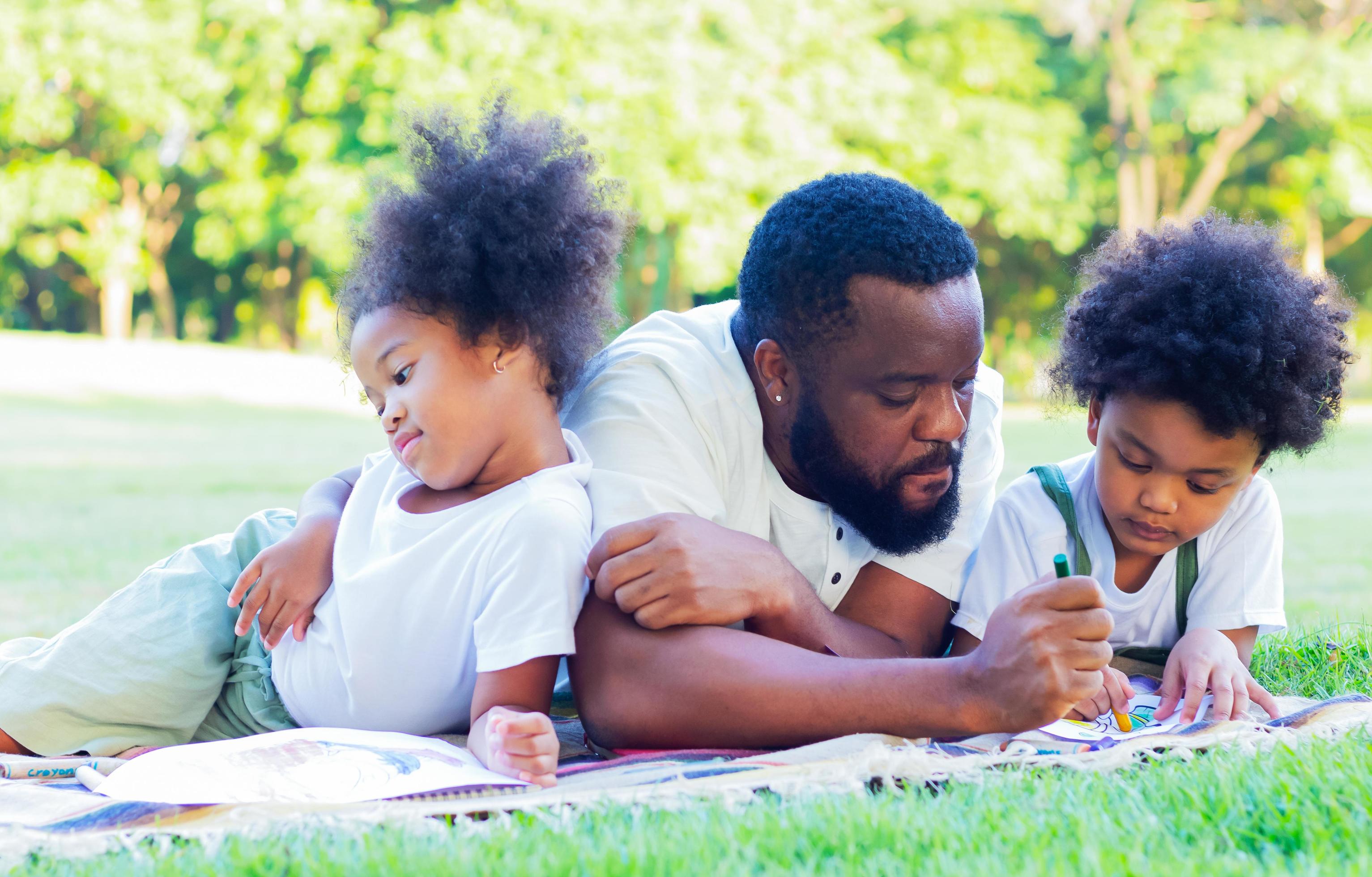 Family happy to lie down on the lawn in the park on vacation. Concept of love and family ties Stock Free