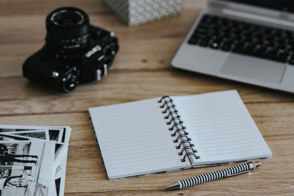 Black-and-white photos with a silver laptop, a smartphone, car keys, pencils and a camera Stock Free