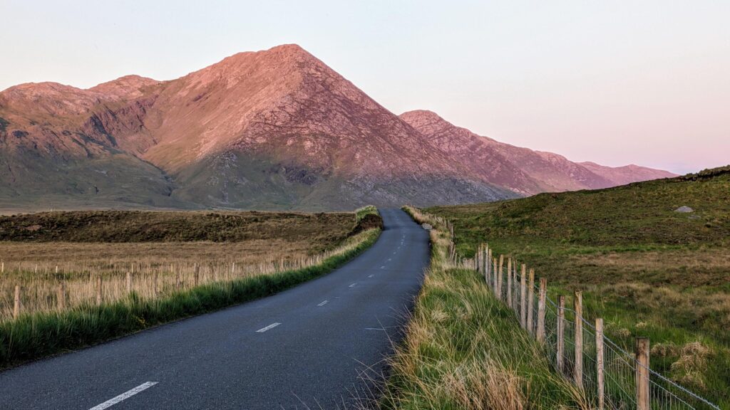 Empty scenic road trough nature and mountains at sunset, Inagh valley, Connemara, Galway, Ireland, landscape background, wallpaper Stock Free