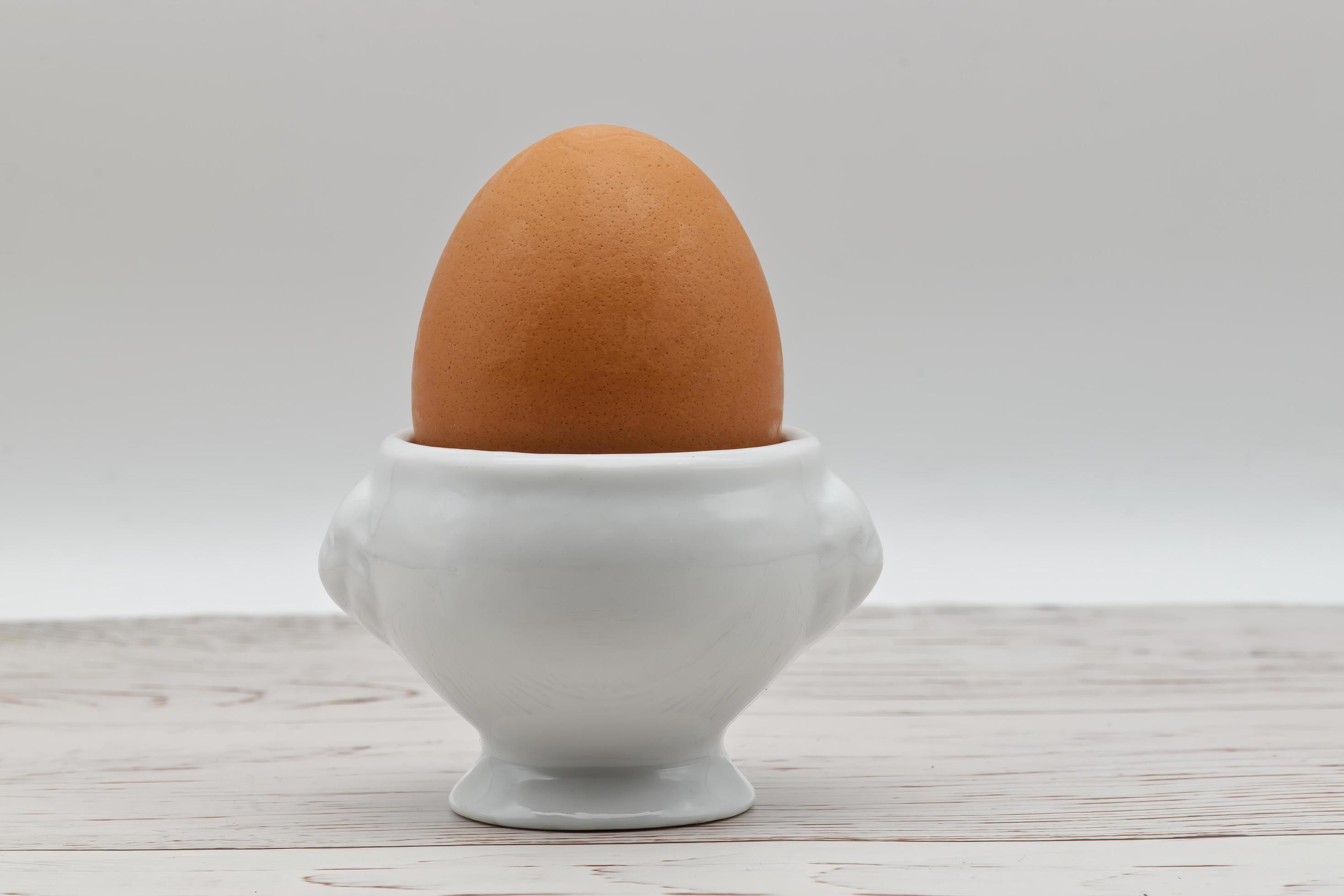 Fresh egg in an eggcup isolated on white background. Traditional food for healthy breakfast. Stock Free