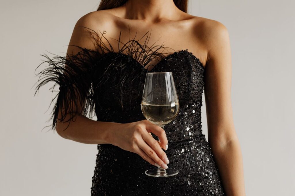 Classy aesthetics – beautiful Asian woman in black evening dress – white wine in a glass Stock Free