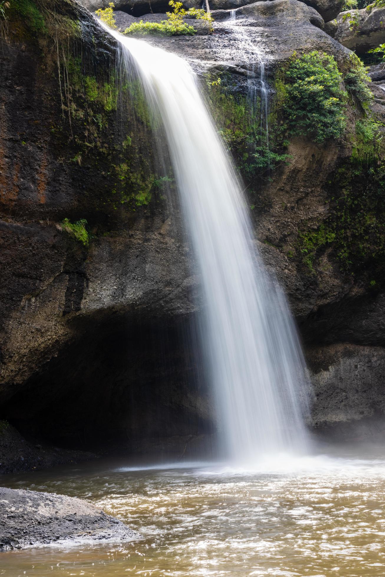 A natural waterfall in a big forest in the midst of beautiful nature. Stock Free