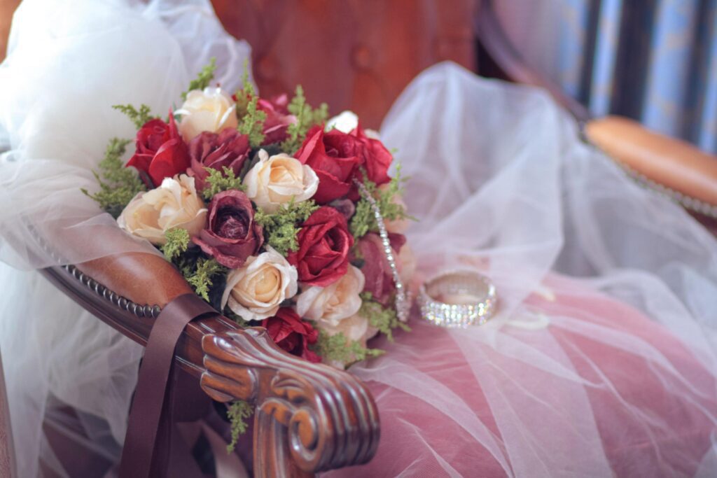 Beautiful rose Flowers bouquet on white vail of bride on vintage chair in wedding ceremony. Valentine day Stock Free