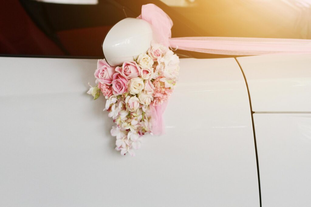 Beautiful Pink roses flower Ribbon decorated on white car door handles for wedding Stock Free