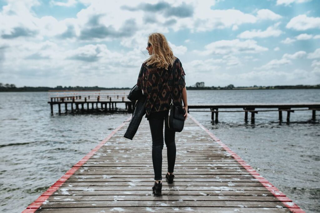 Beautiful blonde woman on a wooden pier by the lake Stock Free