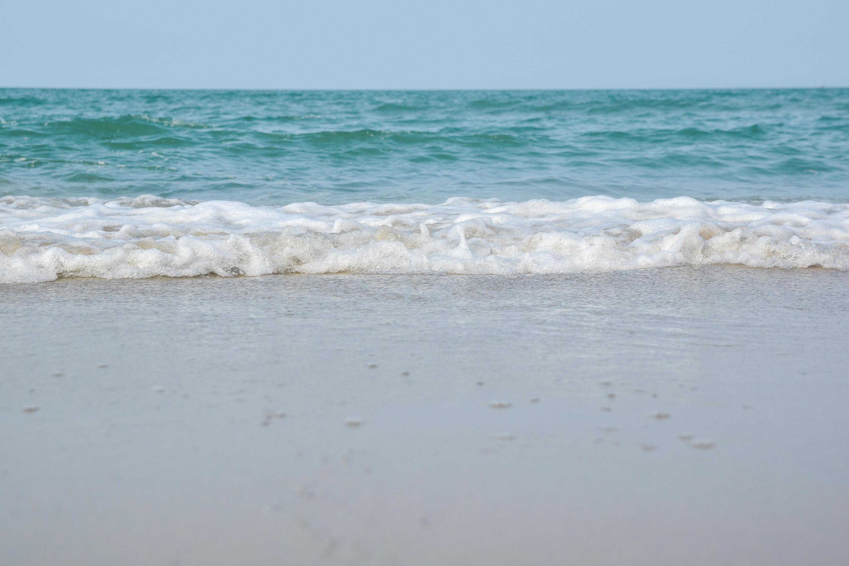 Wide angle shot of sea water hitting the beach, white sponge of the sea, summer nature background image concept. Stock Free