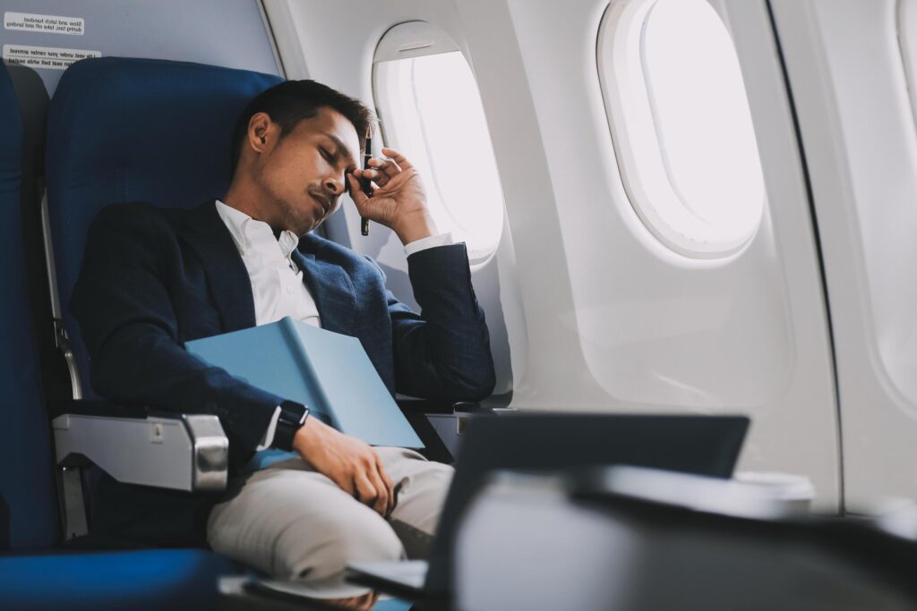 Business Man Having Headache Pain or Frustration Problem in Interior of an Airplane, Corporate Airline Travel Concept Stock Free