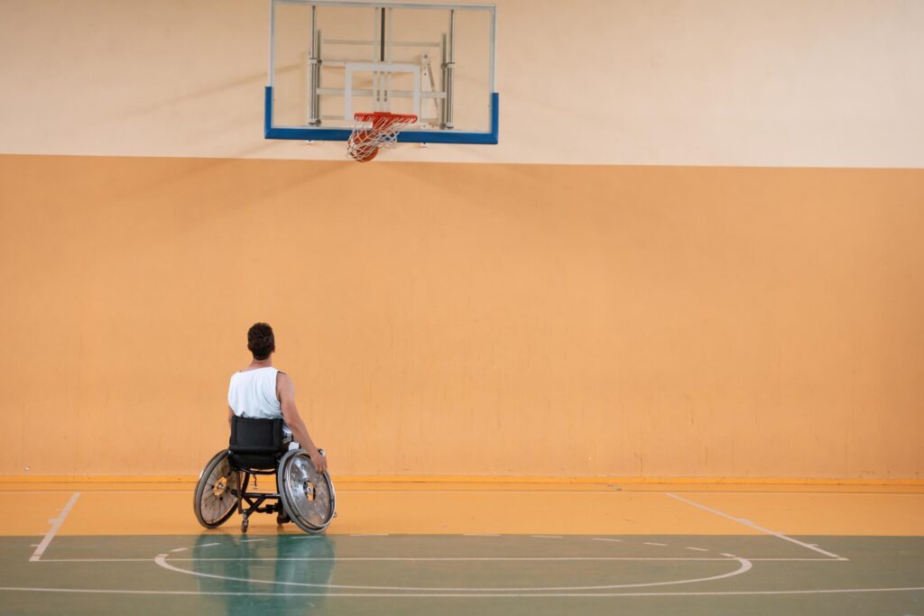 a photo of a war veteran playing basketball with a team in a modern sports arena. The concept of sport for people with disabilities Stock Free