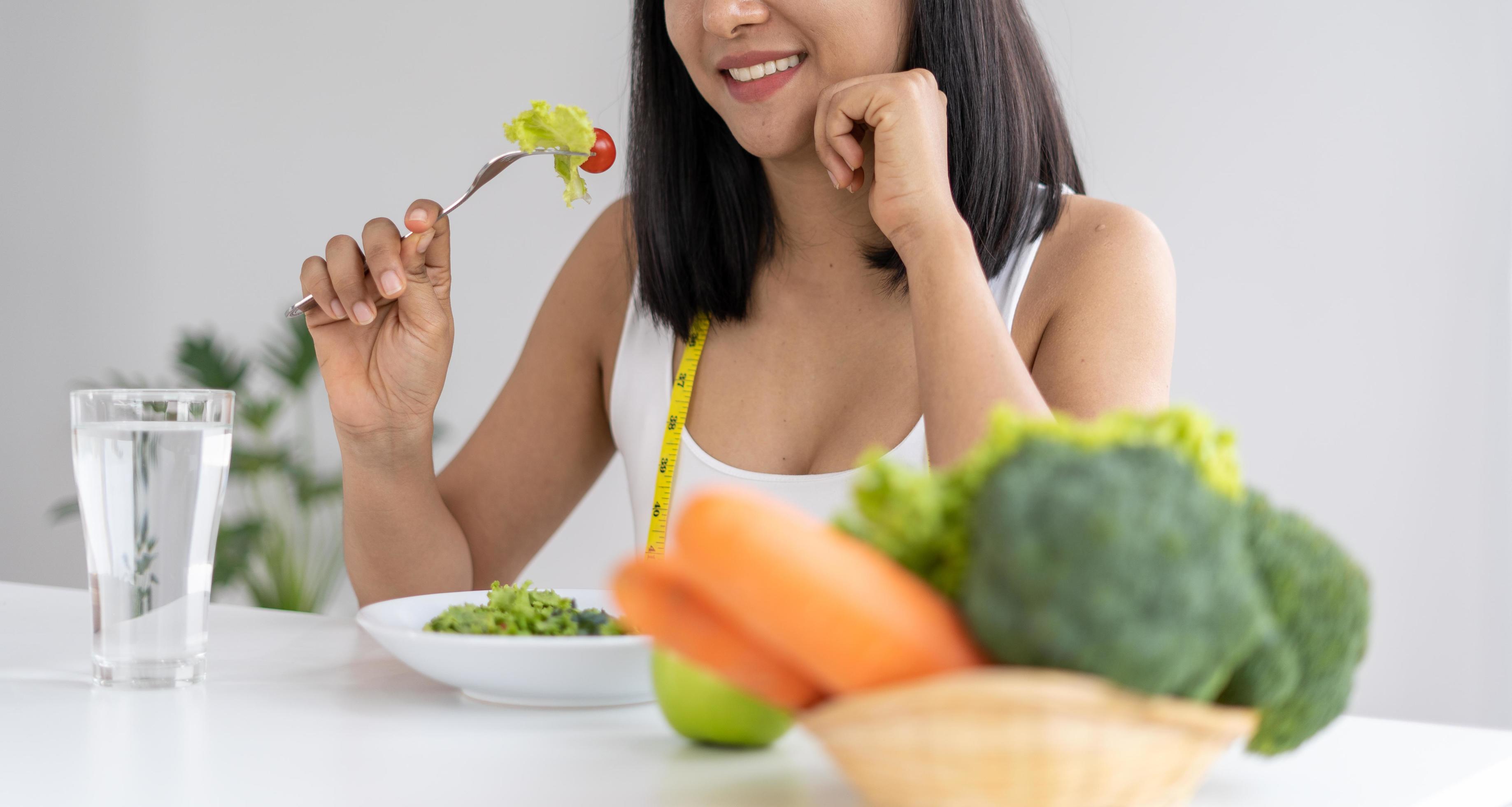 Beautiful Asian women are enjoying eating salad to lose weight. Healthy young woman eating vegetable salad. Dieting , Healthy food concepts. Stock Free