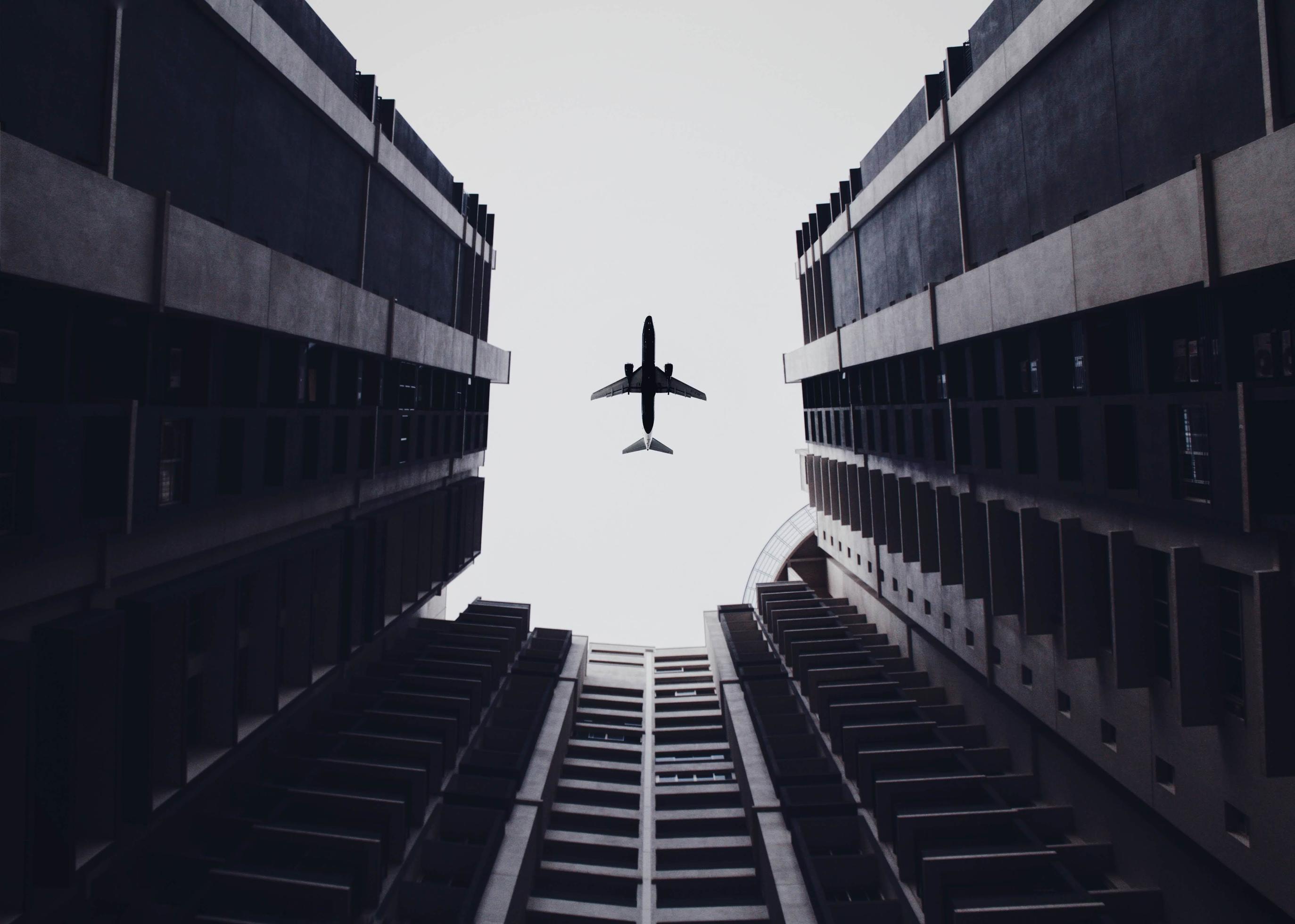 Low angle photo of airliner and buildings Stock Free