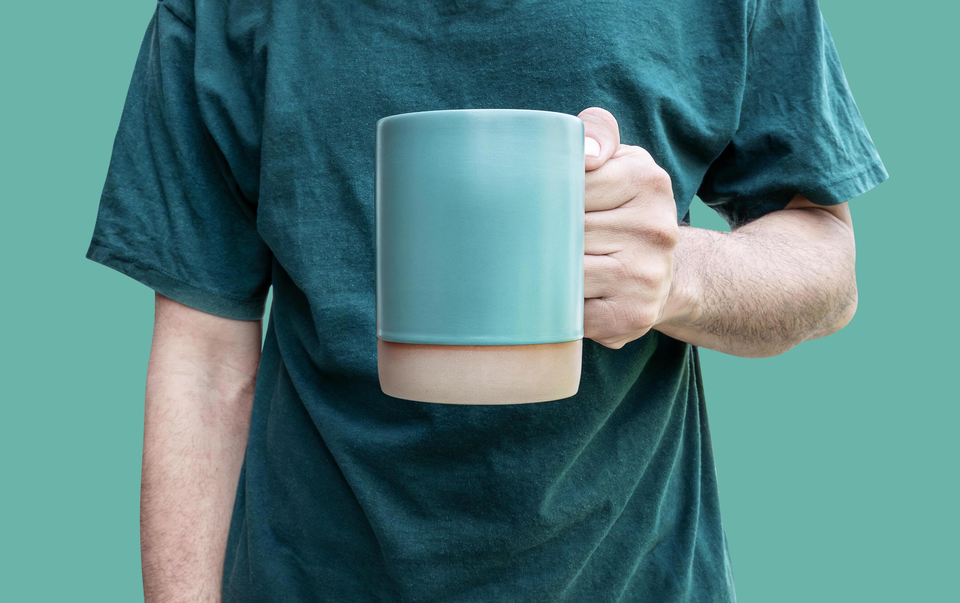 Man hand hold green coffee cup isolated on green background with clipping path Stock Free